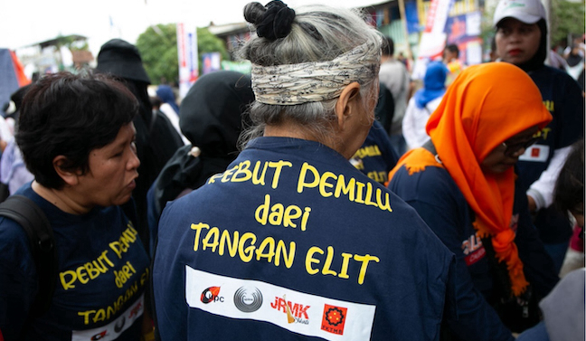 Several residents wore t-shirts that read ‘Seize the Election from the Elite’ during the signing of the political contract between the Urban Poor People’s Network (JRMK) and then presidential candidate Anies Baswedan, ahead of the presidential election on 14 February 2024. It was the last political contract signed by JRMK. /Project Multatuli/Adrian Mulya.
